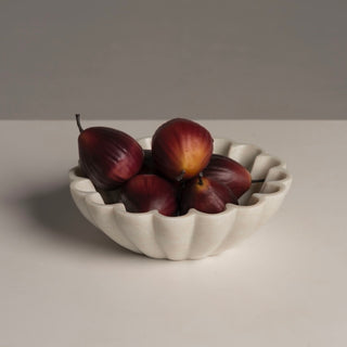 Faux figs gathered in a scalloped marble bowl