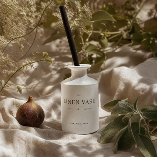 Geranium Sage Signature Reed Diffuser on ecru linen with whole fig and sage sprig