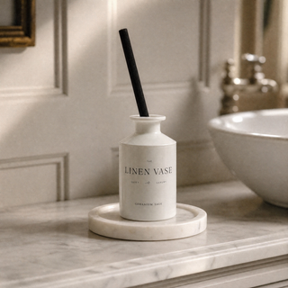 Geranium Sage Signature Reed Diffuser on Marble Candle Plate Holder in a traditional bathroom