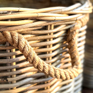 The Grey Rattan Basket with Jute Handles set of four with warm sunlight falling across the jute rope handles