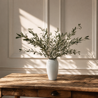 Olive Stem Long Faux Branch Bouquet on a rustic table with a white panelled background