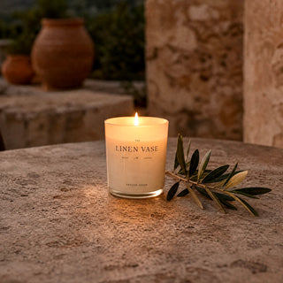 Vetiver Cedar Signature Candle lit on a Mediterranean terrace at dusk
