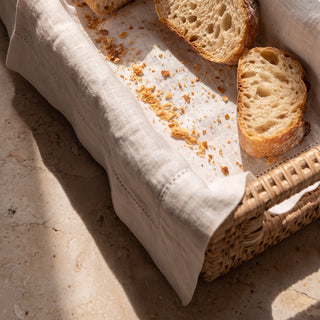 Willa Rattan Narrow Display Tray lined with a Signature Pure Linen Napkin with hemstitch detail and sliced bread